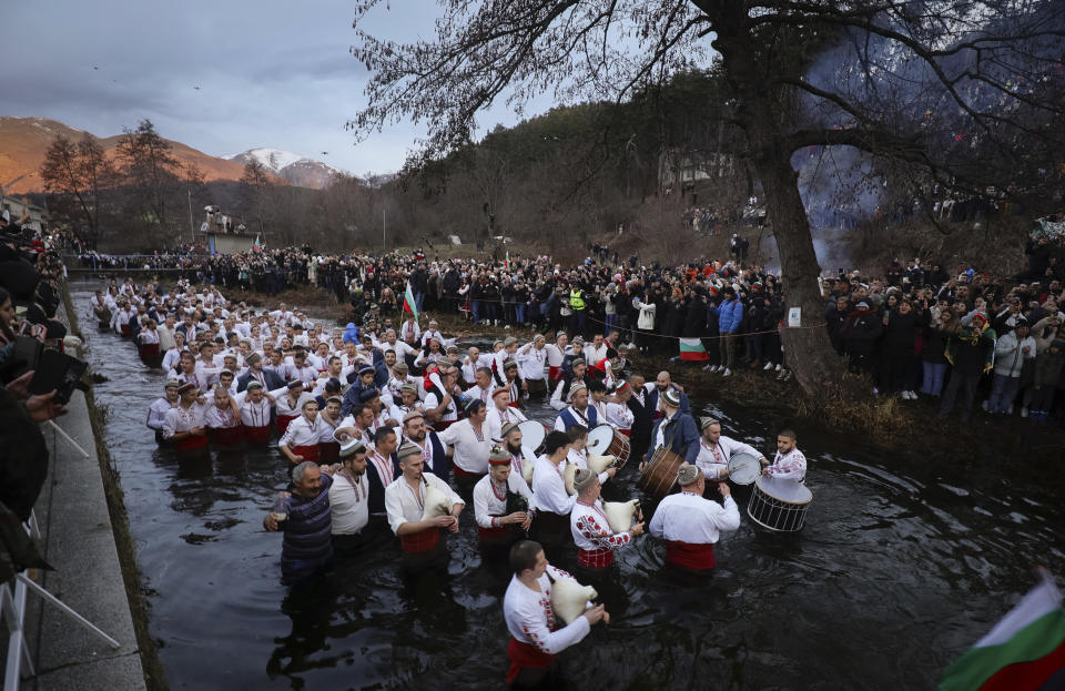 Men play bagpipes and drums as they wade into the cold Tundzha River to celebrate Epiphany, in the town of Kalofer, Bulgaria, Saturday, Jan. 6, 2024. The legend goes that the person who retrieves the wooden cross from the river will be freed from evil spirits and will be healthy throughout the year. Epiphany marks the end of the 12 days of Christmas, but not all Orthodox Christian churches celebrate it on the same day. (AP Photo/Valentina Petrova)