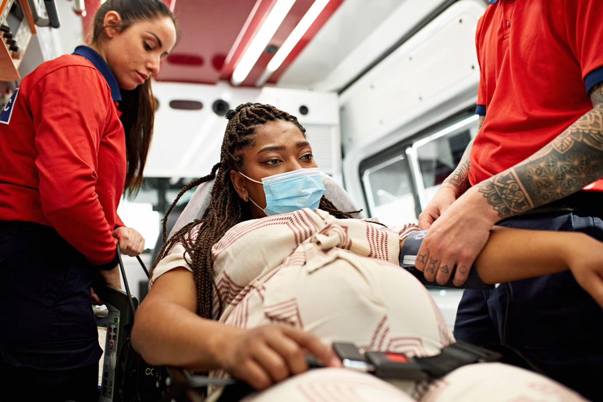 Pregnant woman being cared for inside ambulance Getty Images/xavierarnau