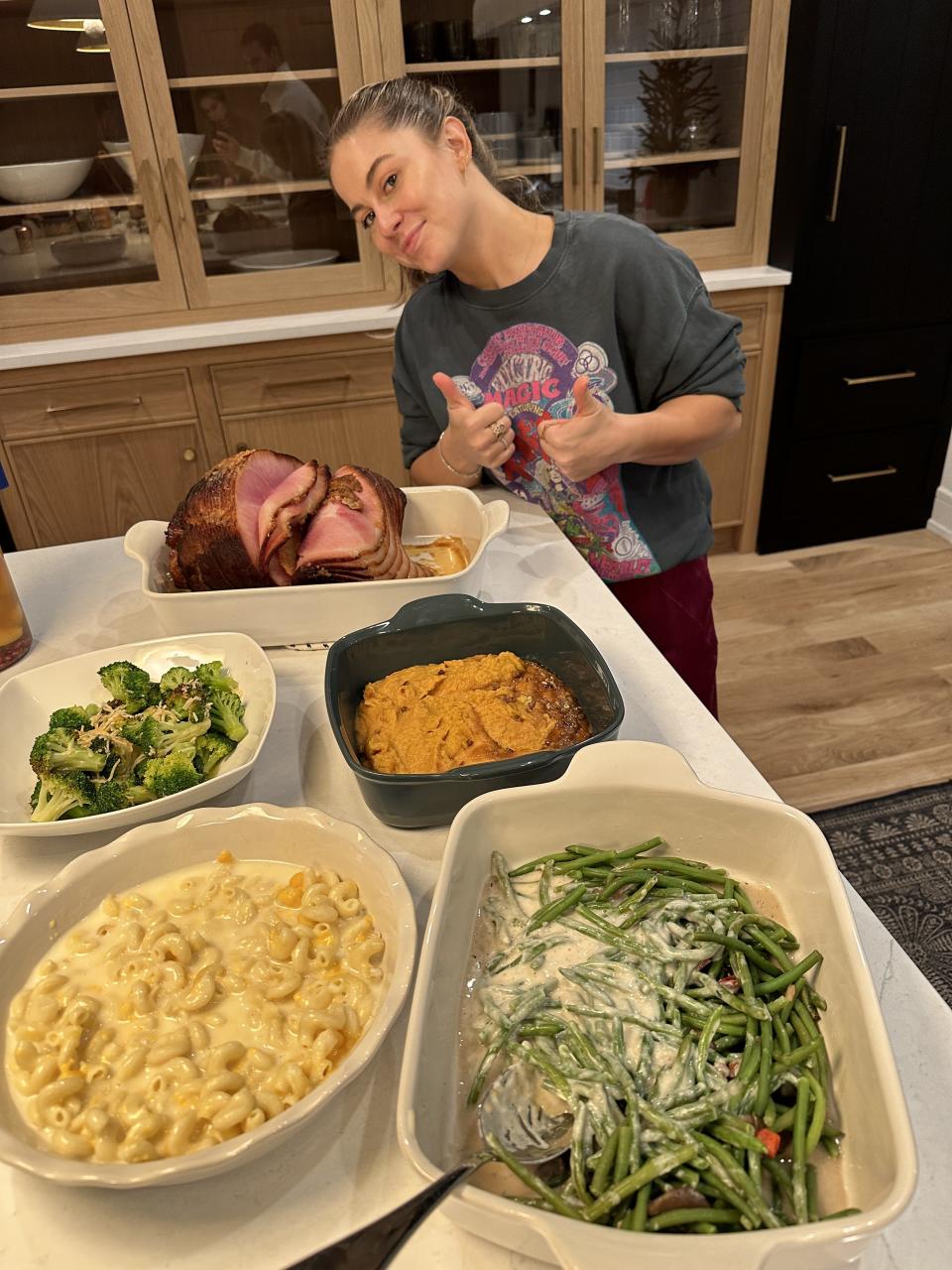 Shawn Johnson preparing dinner with a HoneyBaked meal.