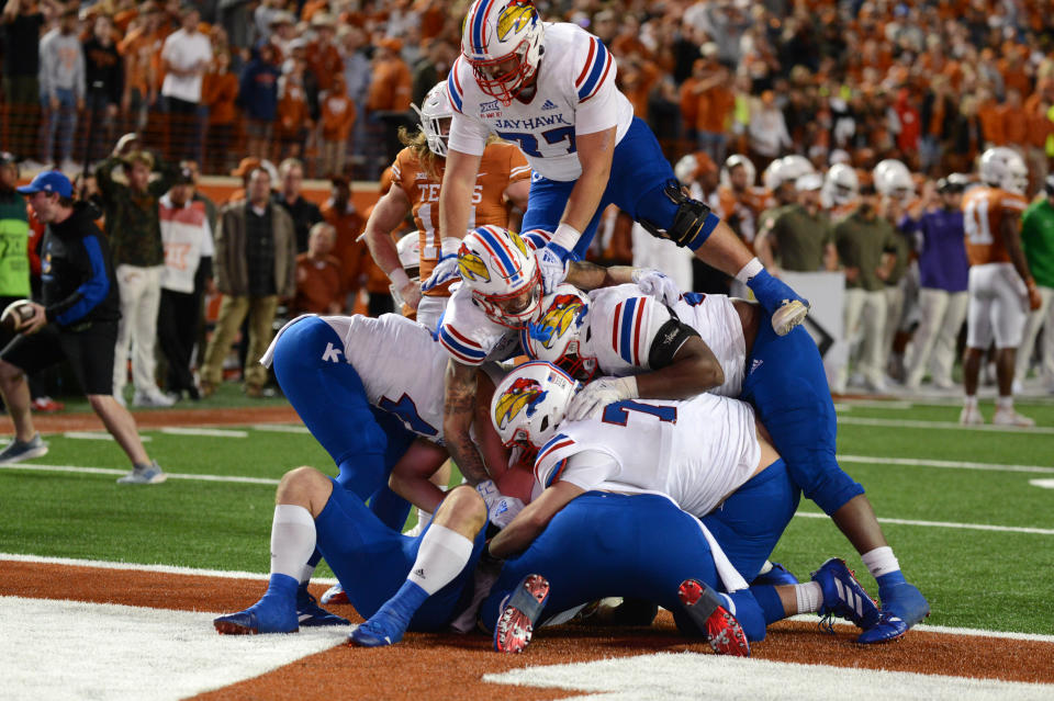 AUSTIN, TX - NOVEMBER 13: Kansas Jayhawks players dog pile on Jared Casey after scoring the winning two-point conversion during game between the Kansas Jayhawks and the Texas Longhorns on November 13, 2021 at Darrell K Royal-Texas Memorial Stadium in Austin, TX.  (Photo by John Rivera/Icon Sportswire via Getty Images)