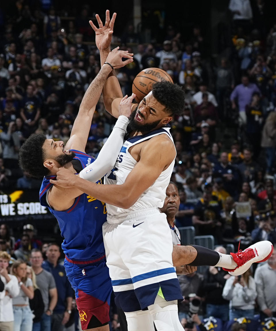 Denver Nuggets guard Jamal Murray, left, fights for control of the ball with Minnesota Timberwolves center Karl-Anthony Towns, front right, in the first half of Game 1 of an NBA basketball second-round playoff series Saturday, May 4, 2024, in Denver. (AP Photo/David Zalubowski)