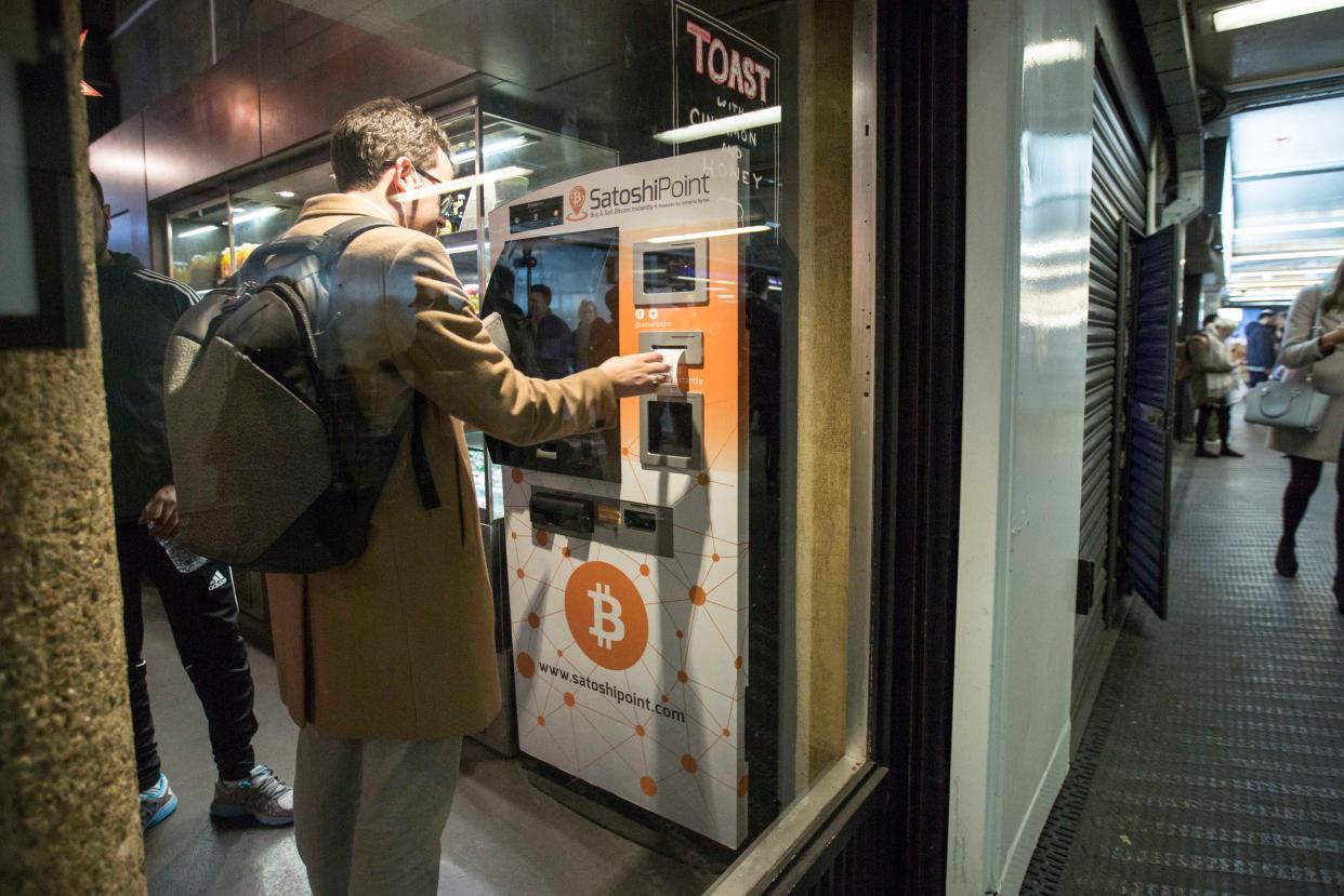 A customer uses a Bitcoin machine in Old Street underground station in London (PA) (PA)