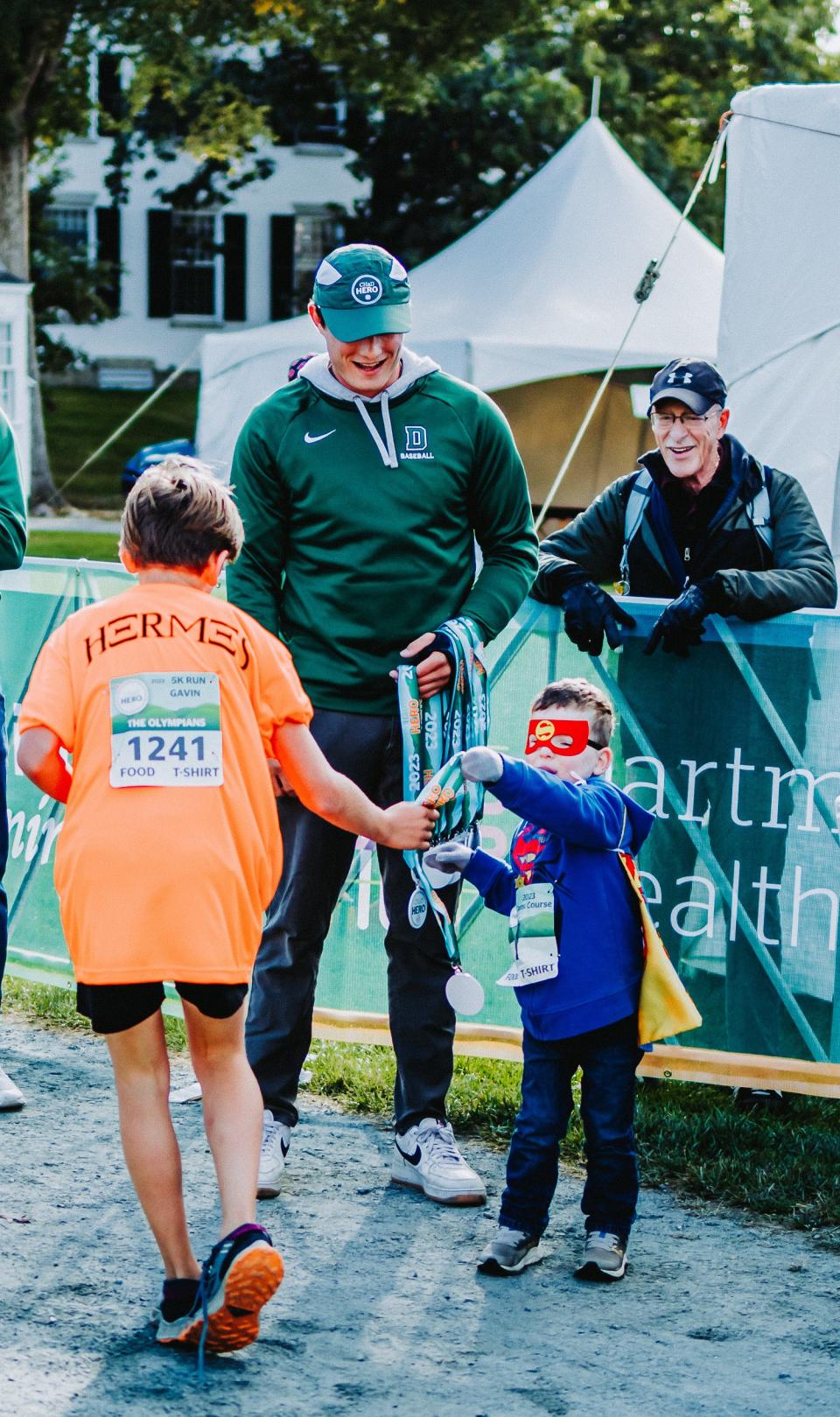 Kid HERO Owen Zak, from Lebanon, NH, hands out participation medals at the Oct. 15, 2023 CHaD HERO event.
