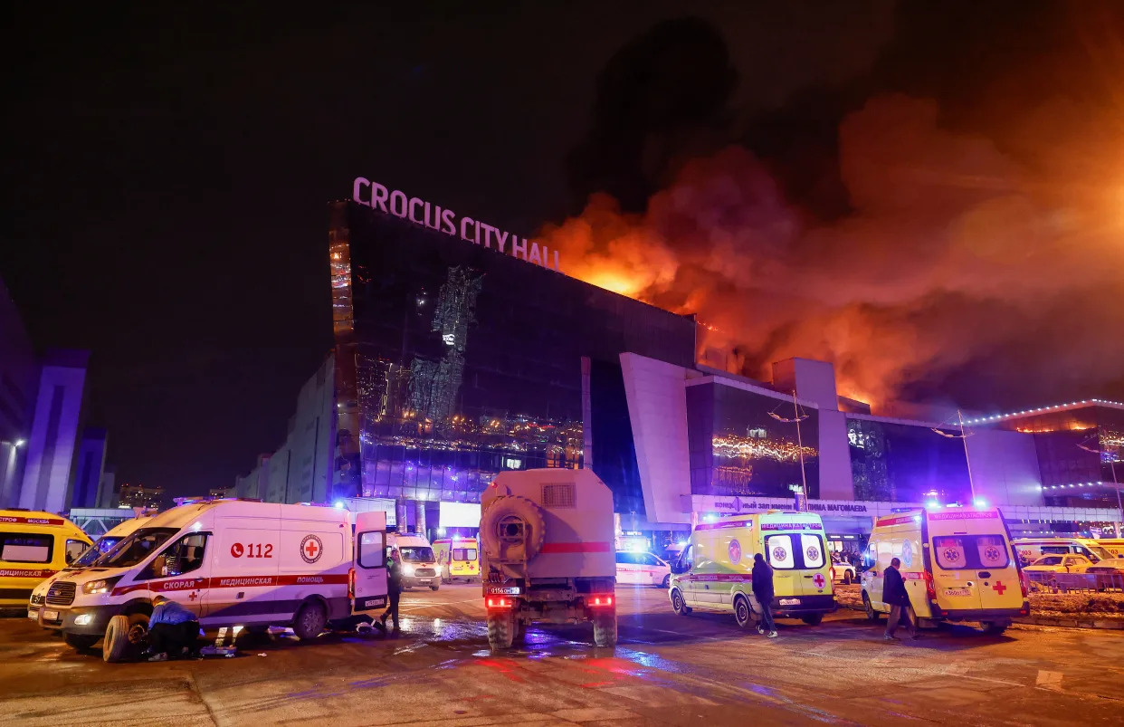 Emergency vehicles are parked near the burning Crocus City Hall following a reported shooting incident on Friday.