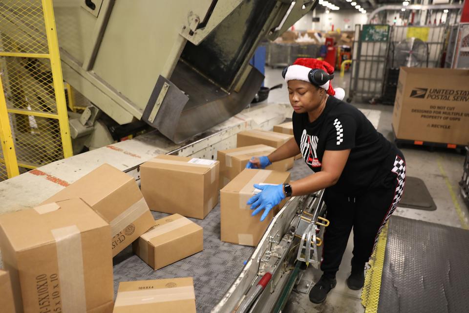 U.S. Postal Service mail handler Nikeisha Mitchell sorts packages at the U.S. Postal service's Royal Palm Processing and Distribution Center.