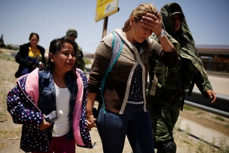 Members of Mexico's National Guard escort a woman and her daughter from Nicaragua after detaining them as they were trying to cross illegally the border between the U.S. and Mexico, in Ciudad Juarez