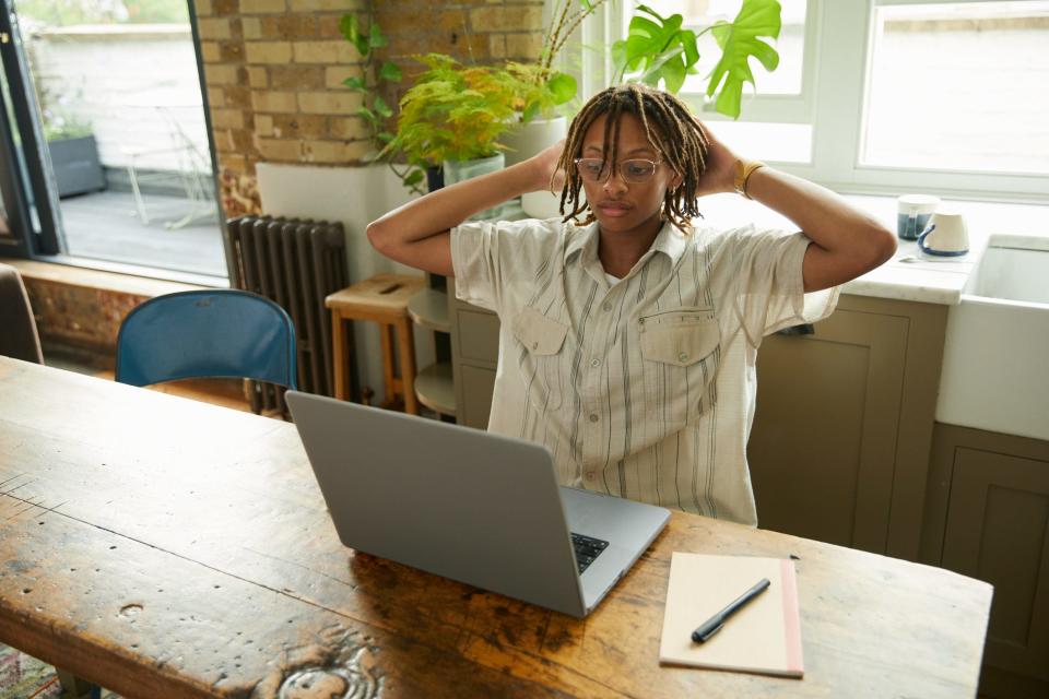 gen z worker leaning back and looking stressed