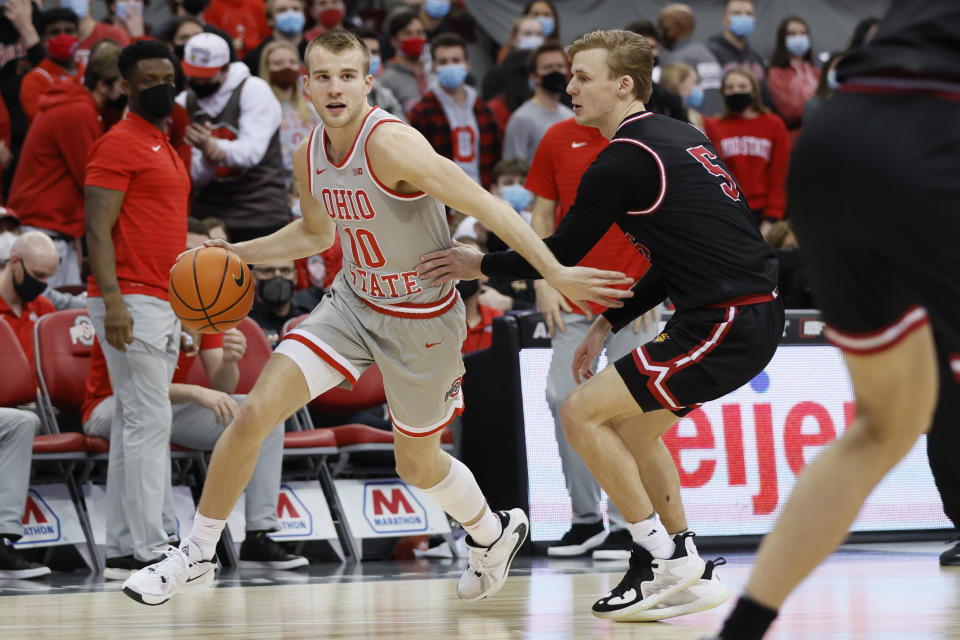 Ohio State's Justin Ahrens, left, dribbles past IUPUI's Nathan McClure during the second half of an NCAA college basketball game Tuesday, Jan. 18, 2022, in Columbus, Ohio. (AP Photo/Jay LaPrete)