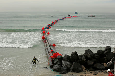 Intake pipes for the Strandfontein temporary desalination plant are pulled ashore near Cape Town, South Africa, February 6, 2018. REUTERS/Mike Hutchings