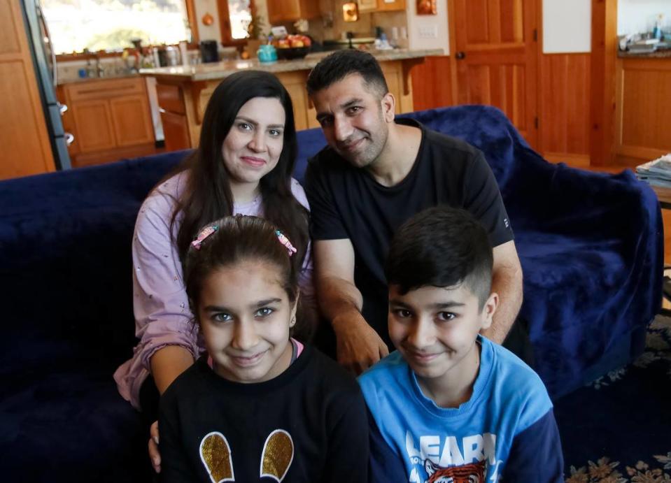 Negina Barakazai and her husband, Kawa Barakazai, pose for a picture with their 8-year-old daughter Maryam and 12-year-old son Ben Yamin in their new Cambria home. The Barakazai family spent more than two years in hiding in Afghanistan and Pakistan before arriving in the United States on Sept. 6, 2023.