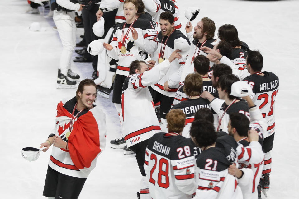 Canada's team players celebrate with the trophy after winning the Ice Hockey World Championship final match between Finland and Canada at the Arena in Riga, Latvia, Sunday, June 6, 2021. (AP Photo/Sergei Grits)