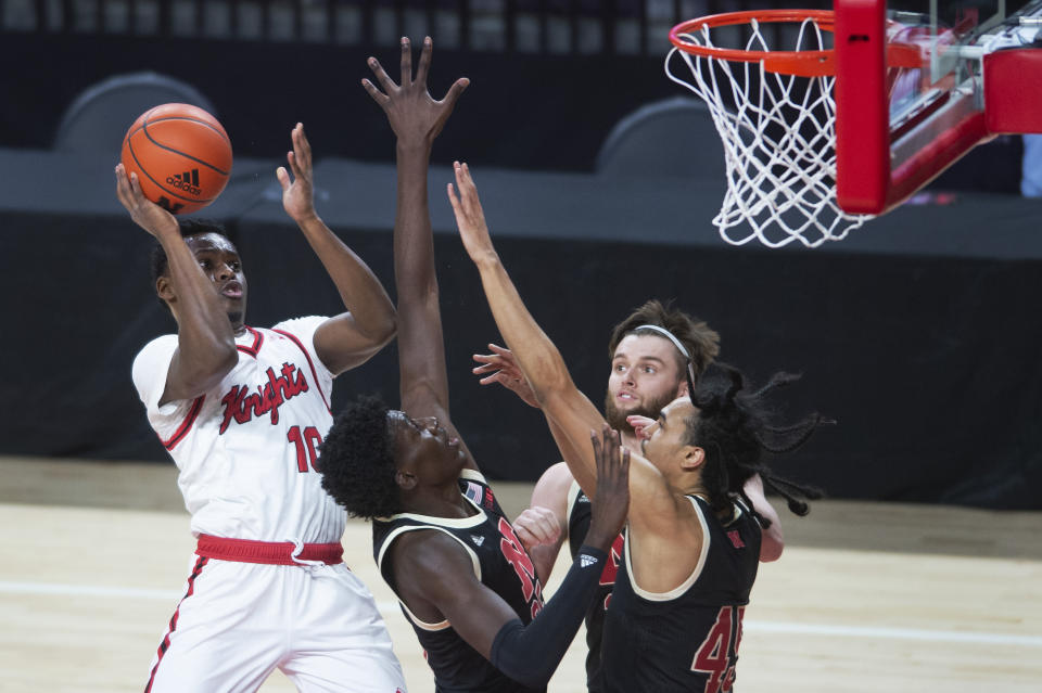 Rutgers' Montez Mathis, left, scores over, second from left to right, Nebraska's Eduardo Andre, Trevor Lakes, and Dalano Banton in the first half of an NCAA college basketball game Monday, March 1, 2021, in Lincoln, Neb. (Kenneth Ferriera/Lincoln Journal Star via AP)