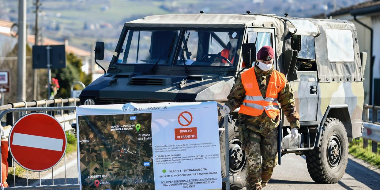 An Italian army soldier blocks off a road leading to the village of Vo'Euganeo, in Italy's northern Veneto region, on Friday, Feb. 28, 2020. Vo'Euganeo is the epicenter of the Veneto cluster of the new virus. (Claudio Fulan/LaPresse via AP)