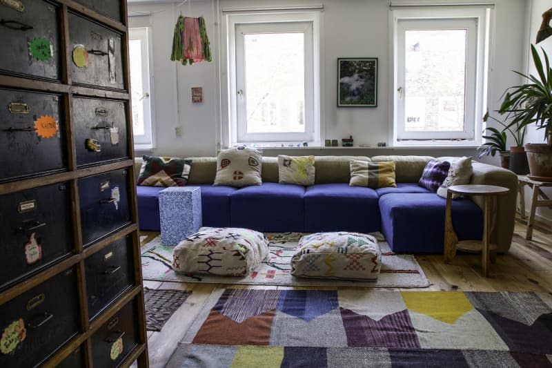 Living room with blue sofa and yellow and other bright colored accents