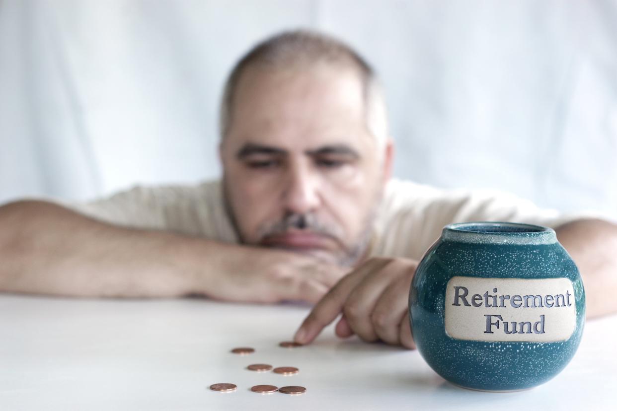 depressed man counting pennies from retirement fund