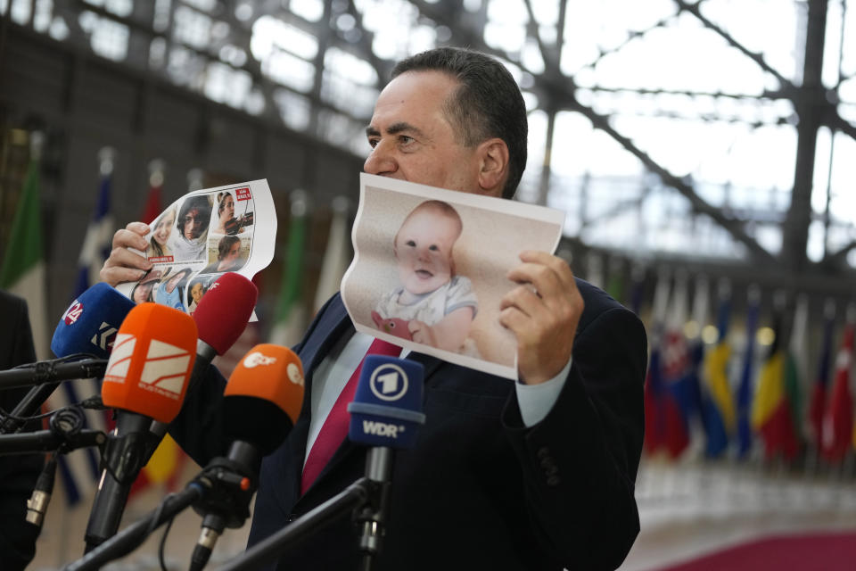 Israel's Foreign Minister Israel Katz holds up a paper photo of hostages kidnapped during the Oct. 7 Hamas cross-border attack in Israel, as he arrives for a meeting of EU foreign ministers at the European Council building in Brussels, Monday, Jan. 22, 2024. European Union Foreign Affairs Ministers meet in Brussels on Monday to discuss the situation in the Middle East and in Ukraine. (AP Photo/Virginia Mayo)