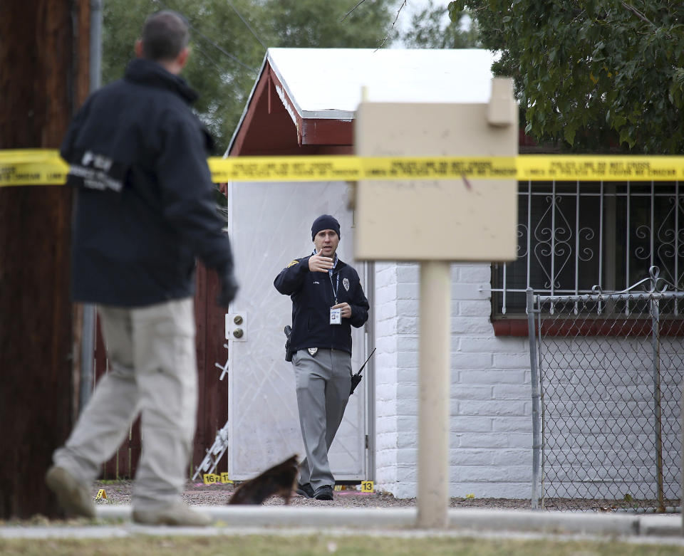 Law enforcement personnel continue their investigation at the scene following a shooting Friday, Nov. 30, 2018, in Tucson, Ariz. A deputy U.S. marshal serving a felony arrest warrant was shot and killed outside the Tucson house the night before. The suspect was arrested after an hour-long standoff at the home. (Ron Medvescek/Arizona Daily Star via AP)