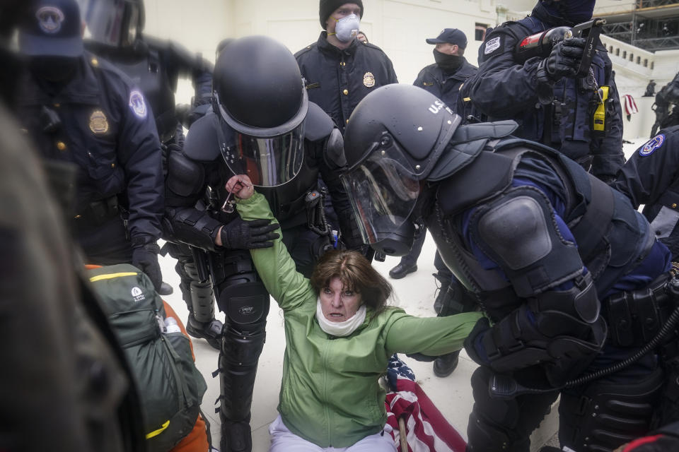 A woman is helped up by police during a rally Wednesday, Jan. 6, 2021, at the Capitol in Washington. (AP Photo/John Minchillo)