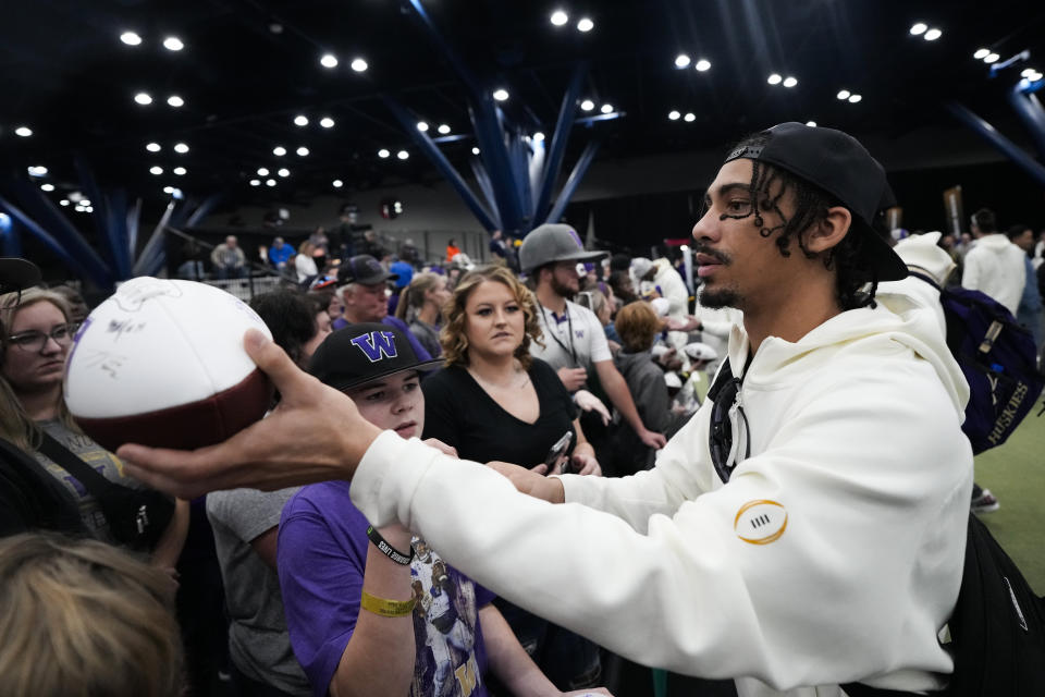 Washington wide receiver Jalen McMillan signs autographs during media day ahead of the national championship NCAA College Football Playoff game between Washington and Michigan Saturday, Jan. 6, 2024, in Houston. The game will be played Monday. (AP Photo/David J. Phillip)