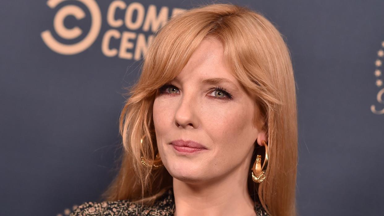 Close up of Kelly Reilly wearing gold earrings and a floral top