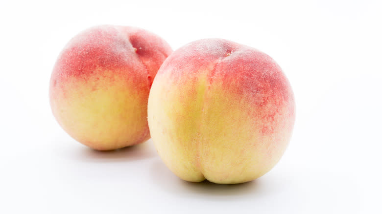 Two red and yellow peaches
