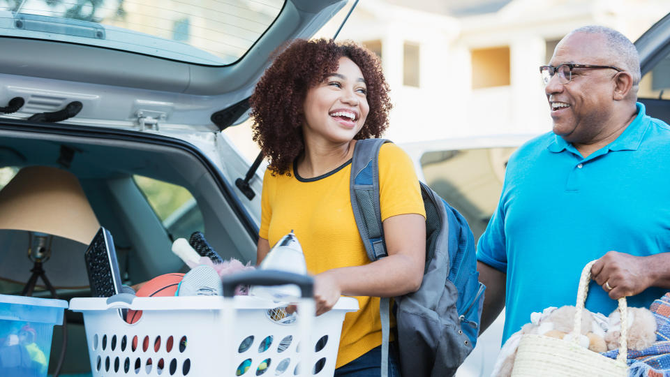 A mature African-American man helping his daughter relocate, perhaps into an apartment or college dorm.