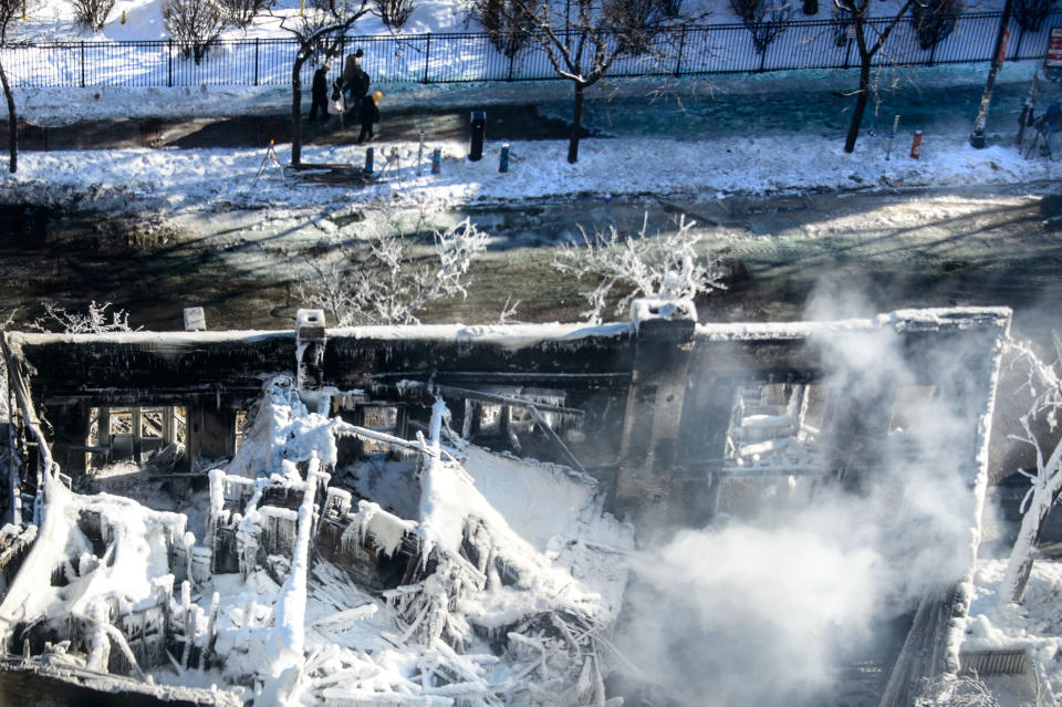 The collapsed rooftop and charred remains is shown on Thursday, Jan. 2, 2014, in Minneapolis, after Wednesday's fire destroyed the building. Fourteen were injured and the cause of the fire is still unclear. (AP Photo/The Star Tribune, Glen Stubbe) MANDATORY CREDIT; ST. PAUL PIONEER PRESS OUT; MAGS OUT; TWIN CITIES TV OUT