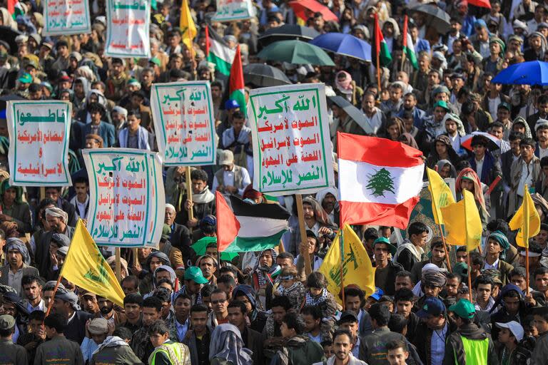 Los yemeníes levantan pancartas antiisraelíes y banderas nacionales palestinas  y libanesas, así como pancartas del movimiento libanés Hezbollah (amarillo) durante una manifestación celebrada en Sanaa, la capital controlada por los hutíes, el 27 de septiembre de 2024 en protesta contra Los ataques de Israel contra el Líbano y Gaza.