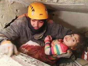 A rescuer brings Nusra Yildiz out from the rubble of a collapsed building in Elazig, Turkey: EPA