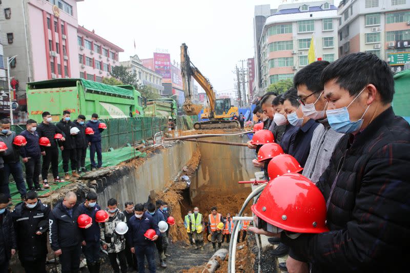 Workers observe a moment of silence at a construction site in Shaoyang