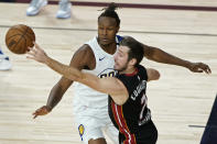 Miami Heat's Goran Dragic (7) passes around Indiana Pacers' Myles Turner (33) during the first half of an NBA basketball first round playoff game Monday, Aug. 24, 2020, in Lake Buena Vista, Fla. (AP Photo/Ashley Landis, Pool)