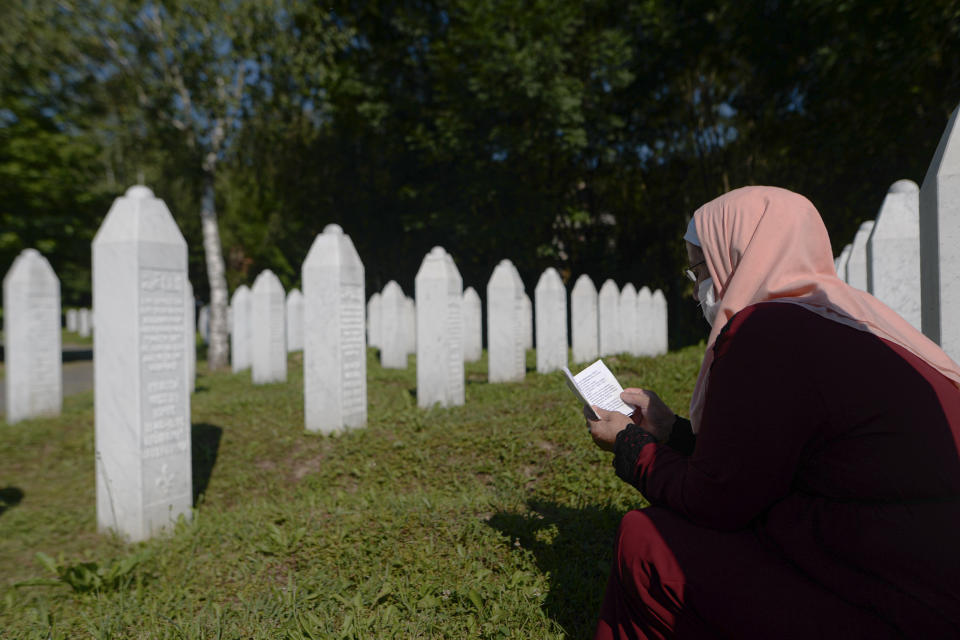 A woman prays in Potocari, near Srebrenica, Bosnia, Saturday, July 11, 2020. Nine newly found and identified men and boys were laid to rest as Bosnians commemorate 25 years since more than 8,000 Bosnian Muslims perished in 10 days of slaughter, after Srebrenica was overrun by Bosnian Serb forces during the closing months of the country's 1992-95 fratricidal war, in Europe's worst post-WWII massacre. (AP Photo/Kemal Softic)