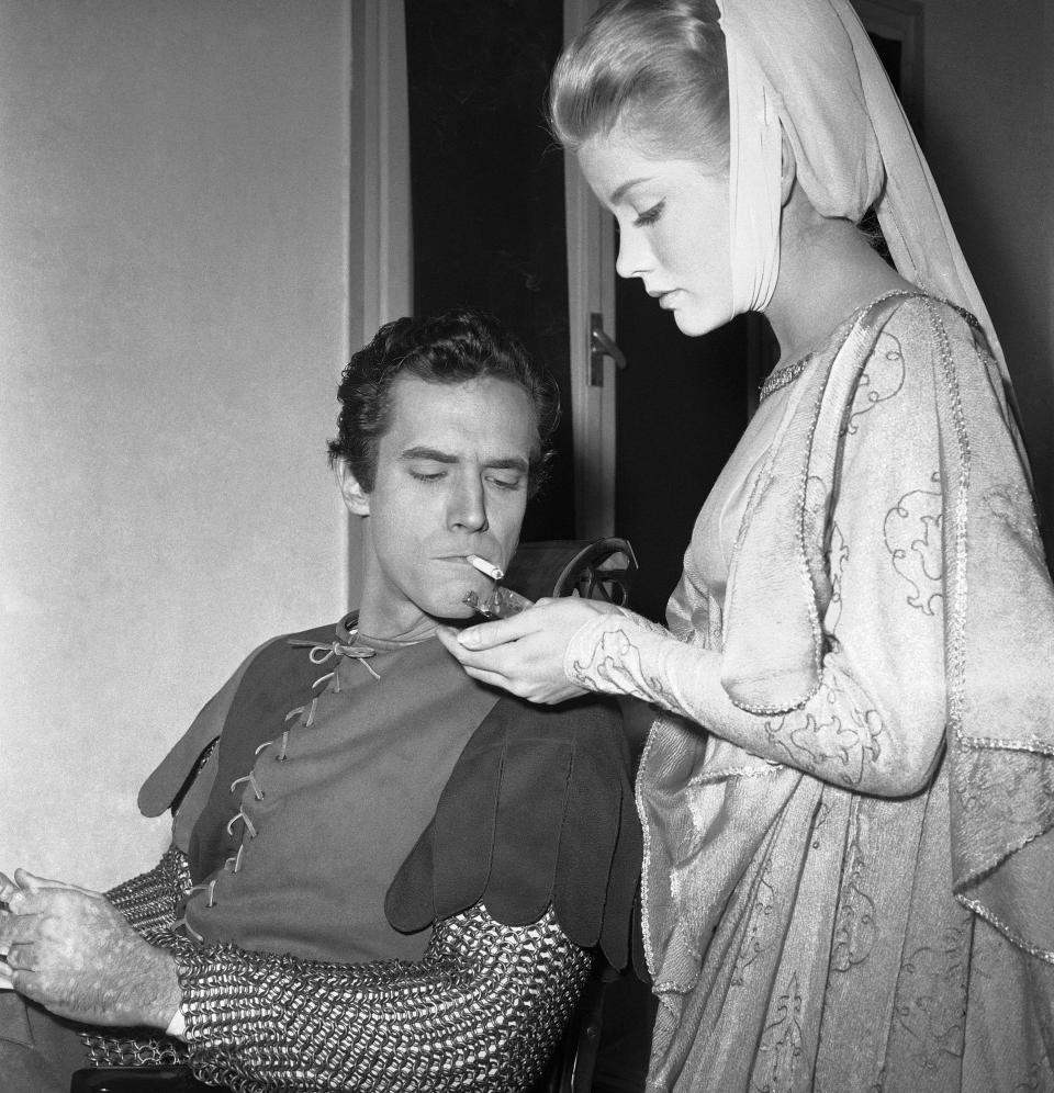 FILE - In this Dec. 19, 1960 file photo, actress Dolores Hart lights a cigarette for actor Bradford Dillman, in a break of the shooting of the movie, "Saint Francis of Assisi," in Rome. Dillman had the starring role of Saint Francis, while Hart played the part of Saint Clare, the nun who founded the order of St. Clare. Hart, whose luminous blue eyes entranced Elvis Presley in his first on-screen movie kiss, is now a cloistered nun and praying for a Christmas miracle. She walked away from Hollywood stardom in 1963 to become a nun in rural Bethlehem, Conn. Now she finds herself back in the spotlight, but this time it's all about serving the King of Kings, not smooching the King of Rock and Roll. The former brass factory that houses Mother Dolores and about 40 other nuns cloistered at the Abbey of Regina Laudis in Bethlehem, Conn., needs millions of dollars in renovations to meet fire and safety codes, add an elevator and make handicap accessibility upgrades. (AP Photo/CR, File)