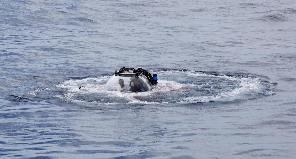 Seychelles President Danny Faure emerges from the ocean inside a submersible, off the coast of Seychelles on Sunday April 14, 2019. In a striking speech delivered from deep below the ocean's surface, the Seychelles president on Sunday made a global plea for stronger protection of the "beating blue heart of our planet." President Danny Faure's call for action, the first-ever live speech from an underwater submersible, came from one of the many island nations threatened by global warming.(AP Photo/Steve Barker)