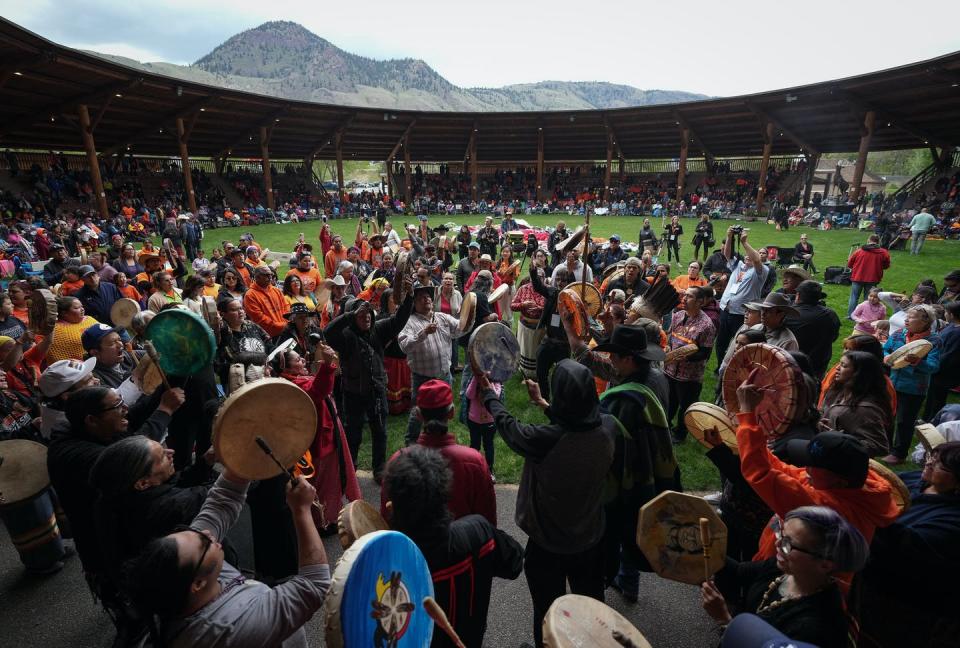 <span class="caption">Drummers play and sing during a May ceremony to mark the one-year anniversary of the discovery of the remains of 215 children at an unmarked burial site at the former Kamloops Indian Residential School in Kamloops, B.C.</span> <span class="attribution"><span class="source">THE CANADIAN PRESS/Darryl Dyck</span></span>