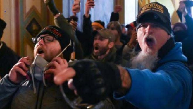 Jon Ryan Schaffer, right, one of the rioters who participated in the 6 January Capitol riot, screams and points after entering the federal building.  (FBI)
