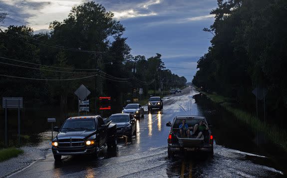 Residents, who evacuated their homes, drive on U.S. Route 190 in Hammond, La.