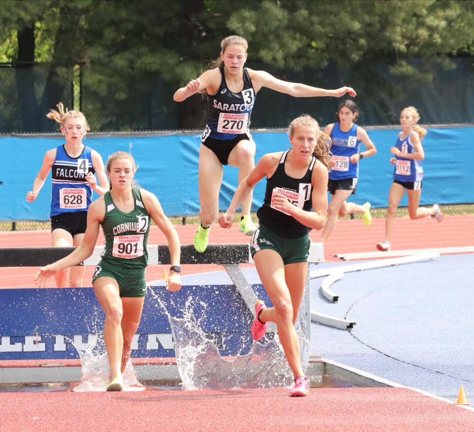 Athletes including Karrie Baloga from Cornwall (901) and Angelina Napoleon from Allegany-Lime (605) compete in the girls 2000 meter steeplechase championship during the New York State Track and Field Championships at Middletown High School, June 10, 2023.