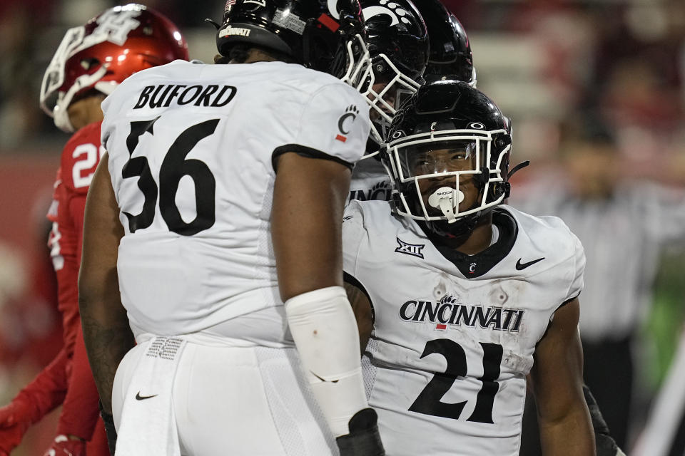 Cincinnati running back Corey Kiner (21) celebrates with Deondre Buford after a touchdown during the fourth quarter of an NCAA college football game against Houston, Saturday, Nov. 11, 2023, in Houston. (AP Photo/Kevin M. Cox)