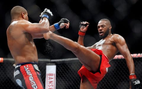  Jon Jones kicks Daniel Cormier during their light heavyweight title - Credit: AP