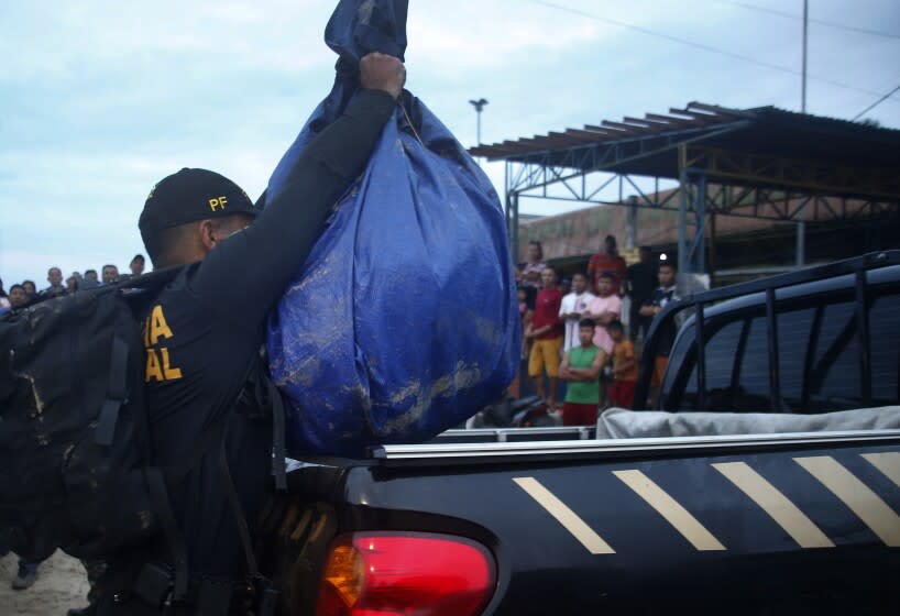 A Federal Police officer loads a truck with items found during a search for Indigenous expert Bruno Pereira and freelance British journalist Dom Phillips in Atalaia do Norte, Amazonas state, Brazil, Sunday, June 12, 2022. Divers from Brazil's firefighters corps found a backpack and laptop Sunday in the remote Amazon area where Pereira and Phillips went missing a week ago, firefighters said. (AP Photo/Edmar Barros)