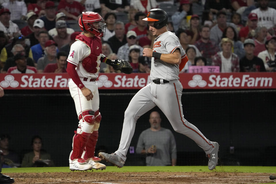 Baltimore Orioles' Ryan Mountcastle, right, scores on a single by Austin Hays as Los Angeles Angels catcher Logan O'Hoppe stands at the plate during the third inning of a baseball game Wednesday, Sept. 6, 2023, in Anaheim, Calif. (AP Photo/Mark J. Terrill)