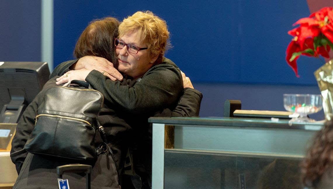 A Delta airlines agent, right, consoles Marie Coon after her flight to the U.S. Virgin Islands was canceled on Thursday, Dec. 22, 2022, in Kansas City. Coon said she was due to fly to St. Croix to celebrate her 45th wedding anniversary with her husband, Mark. She said it was their first big trip together since they met.