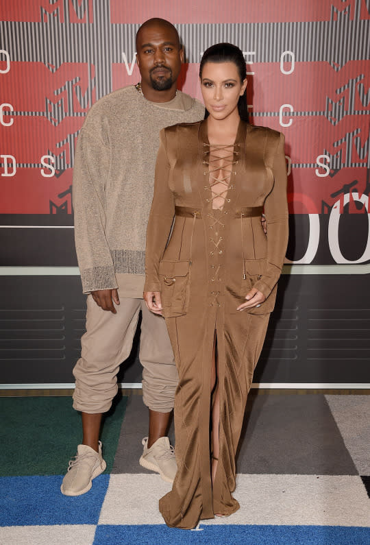 <p>For Kanye West’s big night — he was awarded the Video Vanguard Award — he chose to dress in his understated signature style, rolling up sweatpants and matching an oversized sweater with his Yeezy Boost sneakers. His pregnant wife, Kim Kardashian West, coordinated in a darker brown dress from favorite designer Balmain. The lace-up dress comes from the house’s Resort 2016 collection.</p>