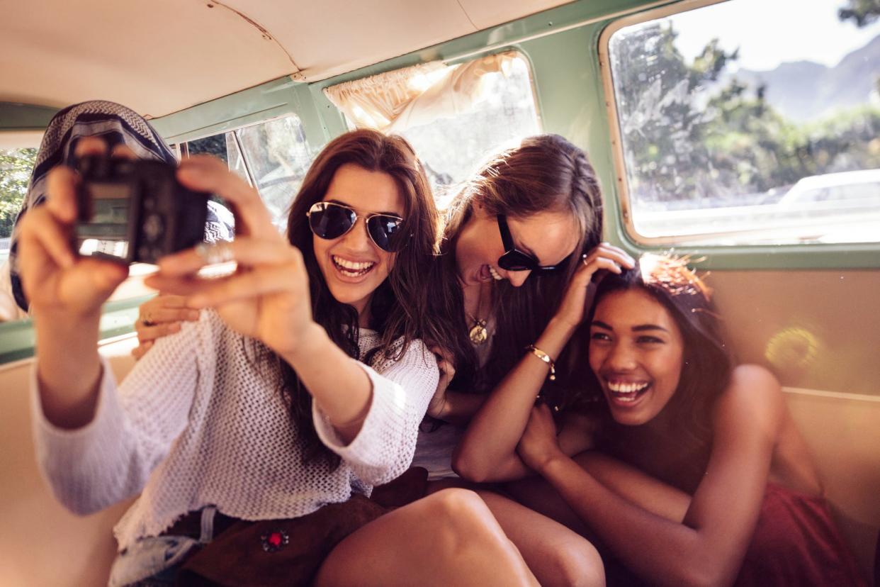 Three girls taking a selfie with a digital camera.