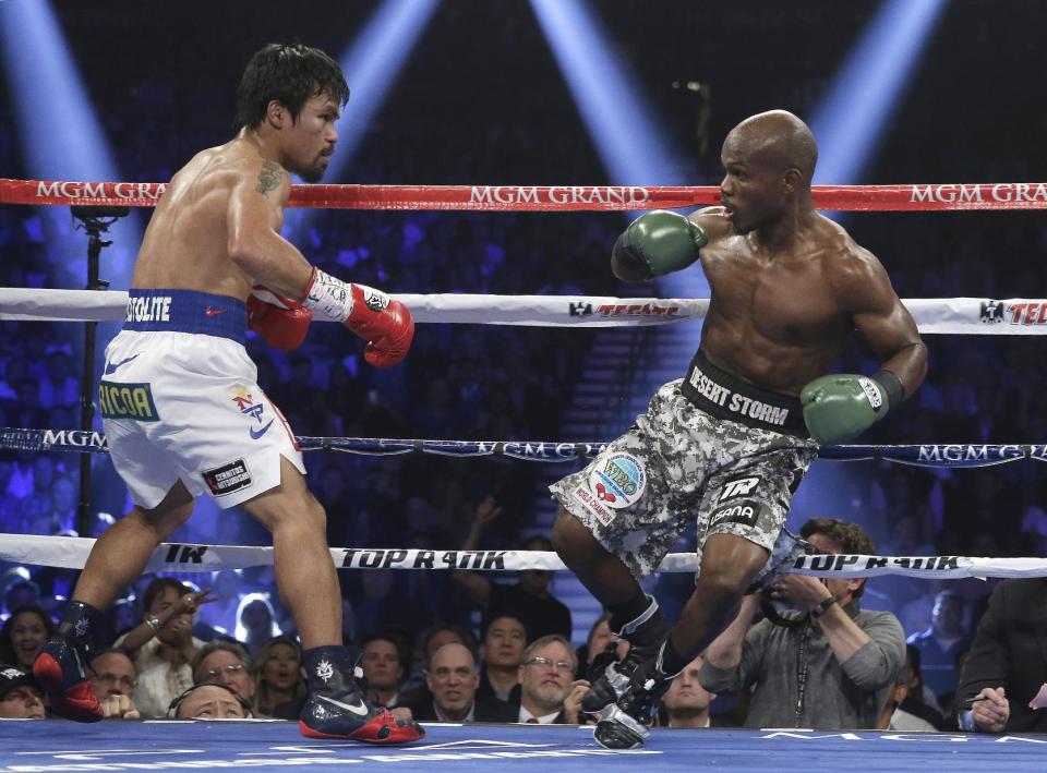 Timothy Bradley, right, loses his footing in front of Manny Pacquiao, of the Philippines, in their WBO welterweight title boxing fight Saturday, April 12, 2014, in Las Vegas. (AP Photo/Isaac Brekken)