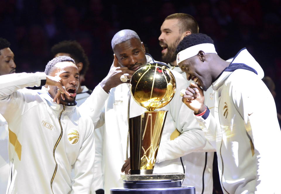 Toronto Raptors' Norman Powell, Serge Ibaka, Marc Gasol and Pascal Siakam , from left, stand with their rings behind the Larry O'Brien NBA Championship Trophy before playing the New Orleans Pelicans in Toronto on Tuesday Oct. 22, 2019. The Raptors defeated the Golden State Warriors to win the NBA title for the first time in franchise history. (Frank Gunn/The Canadian Press via AP)