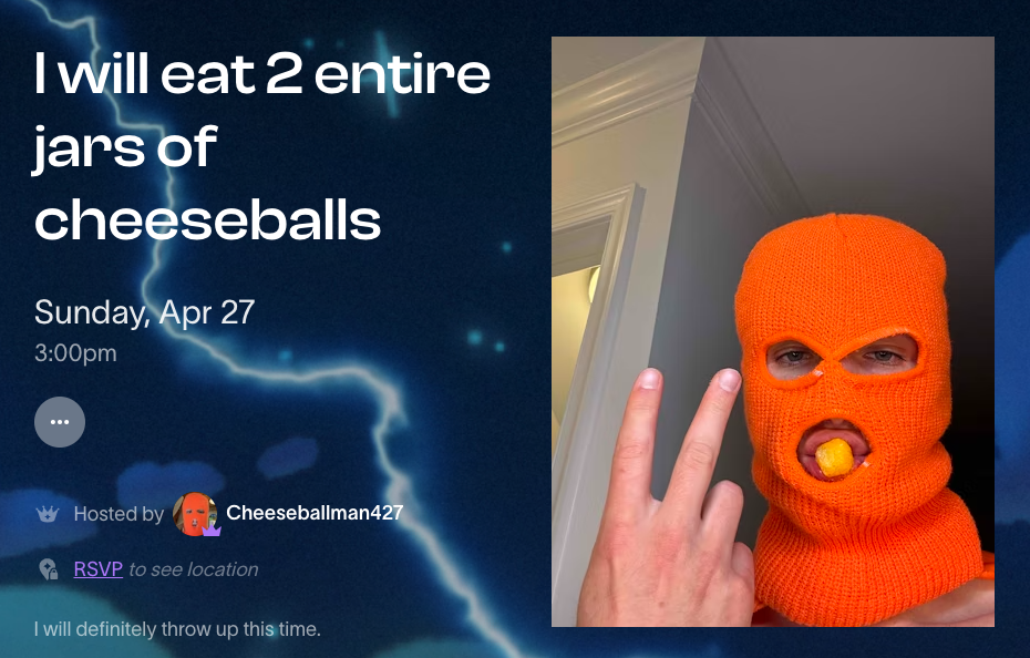 A person poses with an orange-knitted mask, with holes for eyes and mouth, where a cheeseball is placed. They are gesturing a 'two' sign
