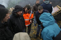 Farmers watch on a smartphone French Prime Minister Gabriel Attal announcing new measures for farmers on a blocked highway, Thursday, Feb.1, 2024 in Chilly-Mazarin, south of Paris. Protests have been held across the EU for most of the week and hundreds of angry farmers driving heavy-duty tractors arrived at European Union headquarters, bent on getting their complaints about excessive costs, rules and bureaucracy heard and fixed by EU leaders at a summit Thursday in Brussels, Belgium. (AP Photo/Christophe Ena)