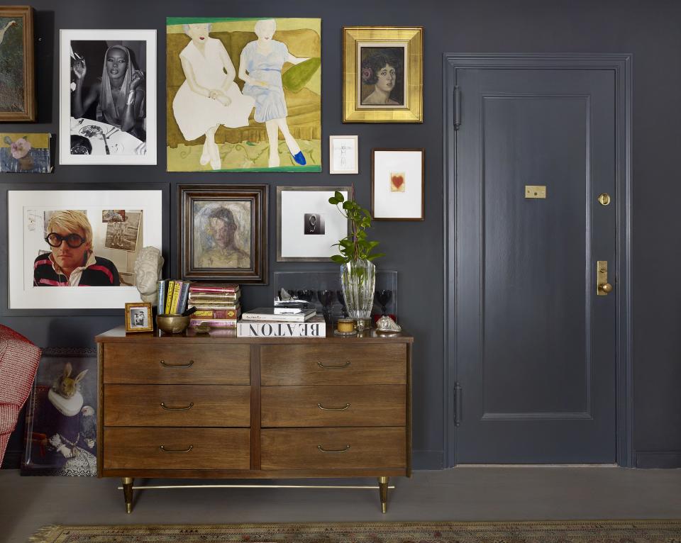 “The photograph of David Hockney [pictured in the bottom left corner] was taken by my late friend and architect David Collins, who designed my original salon at Bergdorf’s. When he passed away unexpectedly, I wanted a part of him, and bought this at a Christie’s auction in London,” says Barrett. Also hanging on the gallery wall are a photograph of Grace Jones by Patrick McMullan, an oil-on-canvas painting by Laurie Ogle, a painting by Heidi Becker, and a sketch by stage designer Scott Pask. Midcentury cabinet from One Kings Lane. Custom paint color from Benjamin Moore.